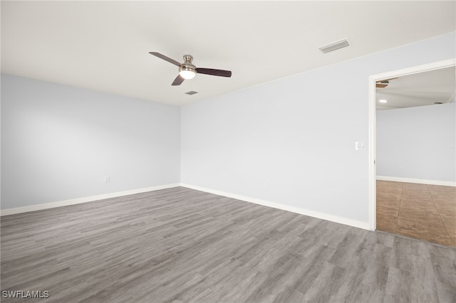 spare room with ceiling fan, wood finished floors, and baseboards