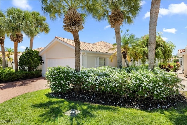 3134 Andorra Ct, Naples, FL 34109 - view of side of home featuring stucco siding, an attached garage, a tiled roof, and driveway