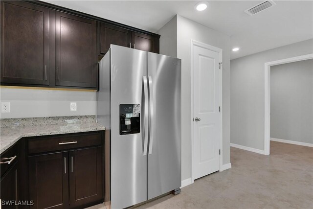 23206 Fitzpatrick Ave, Port Charlotte, FL 33980 - kitchen featuring stainless steel fridge, dark brown cabinets, light stone counters, recessed lighting, and baseboards