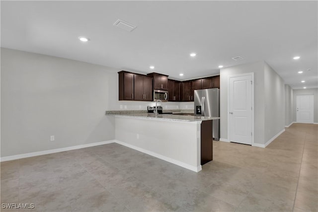 23206 Fitzpatrick Ave, Port Charlotte, FL 33980 - kitchen with stainless steel appliances, recessed lighting, dark brown cabinetry, baseboards, and a peninsula