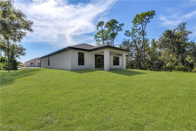 23206 Fitzpatrick Ave, Port Charlotte, FL 33980 - rear view of house with a lawn and stucco siding