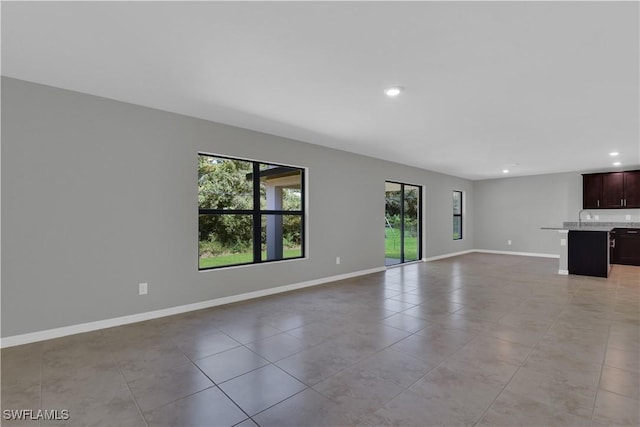 23206 Fitzpatrick Ave, Port Charlotte, FL 33980 - unfurnished living room with recessed lighting, light tile patterned floors, and baseboards