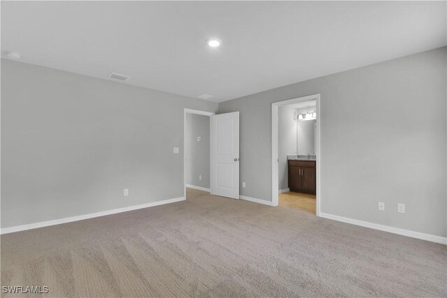 23206 Fitzpatrick Ave, Port Charlotte, FL 33980 - unfurnished bedroom featuring light colored carpet, baseboards, ensuite bathroom, and recessed lighting