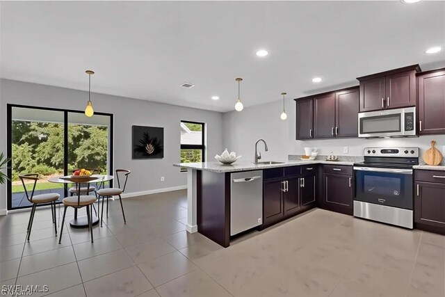 23206 Fitzpatrick Ave, Port Charlotte, FL 33980 - kitchen featuring stainless steel appliances, a peninsula, recessed lighting, pendant lighting, and light stone counters
