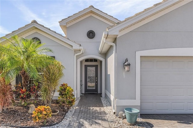 2736 Lambay Ct, Cape Coral, FL 33991 - doorway to property featuring stucco siding and an attached garage