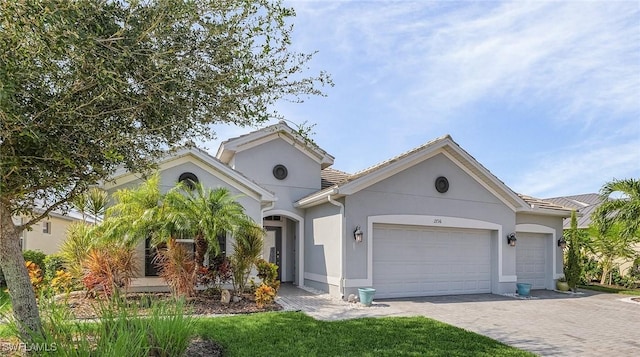 2736 Lambay Ct, Cape Coral, FL 33991 - view of front of home with an attached garage, stucco siding, and decorative driveway