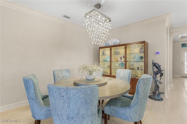 2736 Lambay Ct, Cape Coral, FL 33991 - dining space featuring crown molding, baseboards, a chandelier, and arched walkways