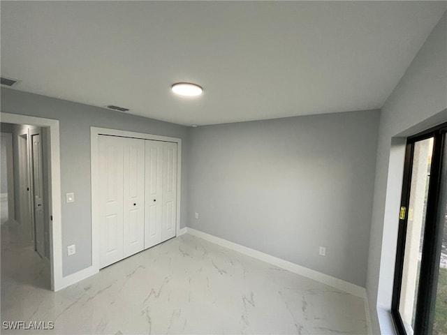 unfurnished bedroom with baseboards and light marble finish flooring