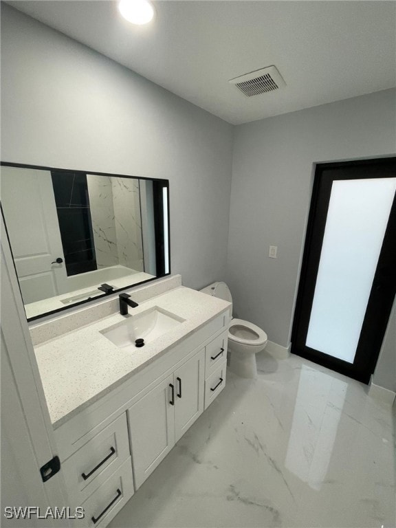 bathroom with marble finish floors, vanity, and toilet