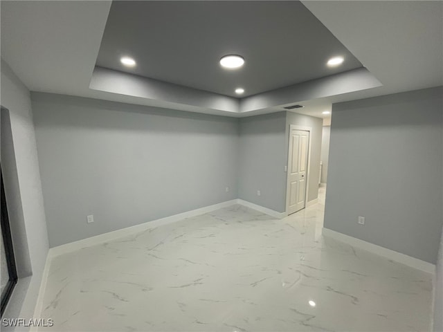 finished basement featuring baseboards, recessed lighting, and light marble finish flooring