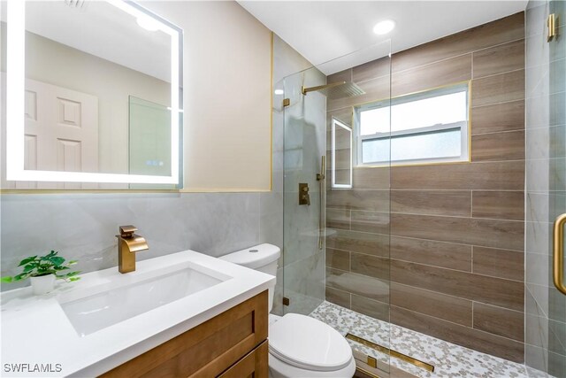 203 Carol Way, Fort Myers, FL 33905 - bathroom featuring toilet, a tile shower, vanity, and tile walls