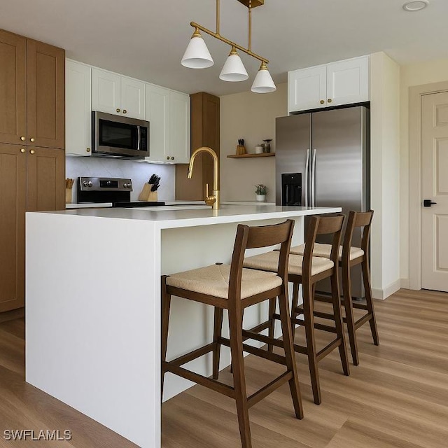 203 Carol Way, Fort Myers, FL 33905 - kitchen with stainless steel appliances, a sink, light wood-type flooring, and white cabinetry