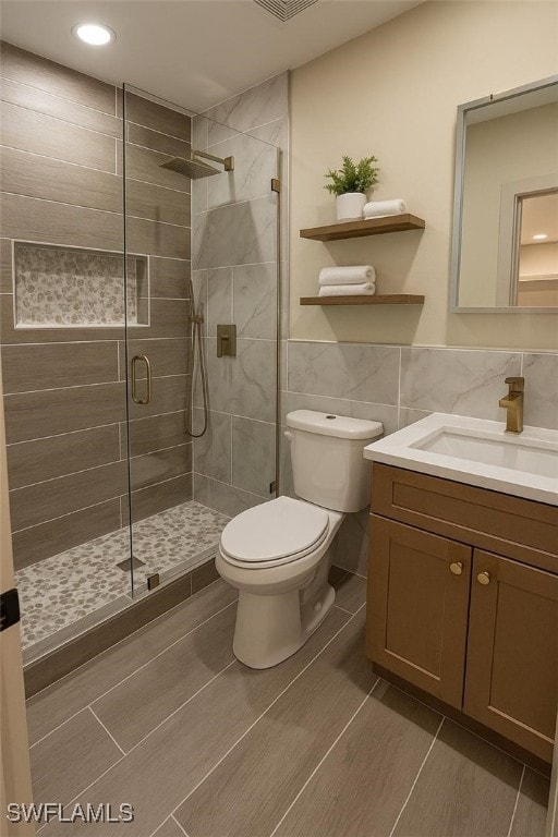 203 Carol Way, Fort Myers, FL 33905 - bathroom featuring a shower stall, toilet, vanity, tile walls, and recessed lighting