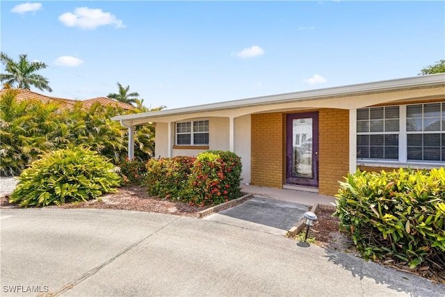 12206 Boat Shell Dr, Matlacha Isles, FL 33991 - doorway to property featuring brick siding and covered porch