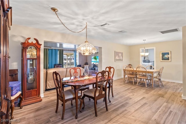 12206 Boat Shell Dr, Matlacha Isles, FL 33991 - dining space with a chandelier, light wood finished floors, and baseboards
