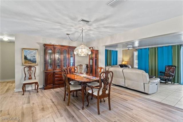 12206 Boat Shell Dr, Matlacha Isles, FL 33991 - dining area with a chandelier, light wood-style floors, and baseboards
