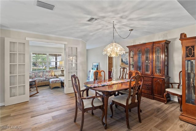 12206 Boat Shell Dr, Matlacha Isles, FL 33991 - dining space with a chandelier and light wood finished floors