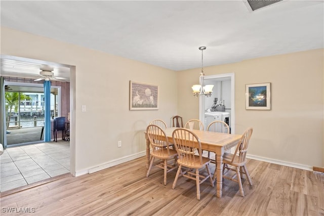 12206 Boat Shell Dr, Matlacha Isles, FL 33991 - dining area with baseboards, a chandelier, and light wood-style floors