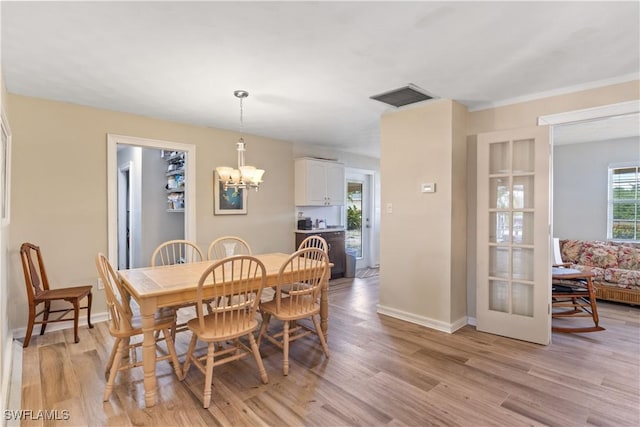 12206 Boat Shell Dr, Matlacha Isles, FL 33991 - dining space featuring a chandelier, light wood-type flooring, and baseboards