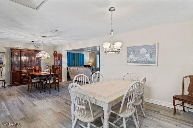 12206 Boat Shell Dr, Matlacha Isles, FL 33991 - dining area featuring a chandelier, light wood-type flooring, baseboards, and ceiling fan
