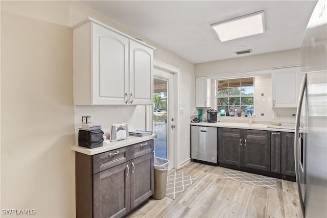 12206 Boat Shell Dr, Matlacha Isles, FL 33991 - kitchen featuring stainless steel appliances, light wood-style floors, white cabinetry, and light countertops
