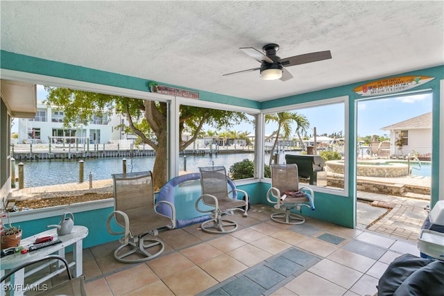 12206 Boat Shell Dr, Matlacha Isles, FL 33991 - sunroom / solarium featuring a ceiling fan, a water view, healthy amount of natural light, and a textured ceiling