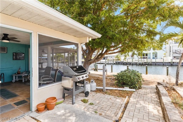 12206 Boat Shell Dr, Matlacha Isles, FL 33991 - view of patio with a sunroom, a water view, ceiling fan, a boat dock, and a grill