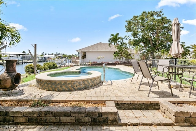 12206 Boat Shell Dr, Matlacha Isles, FL 33991 - view of swimming pool featuring a patio, a water view, and a pool with connected hot tub