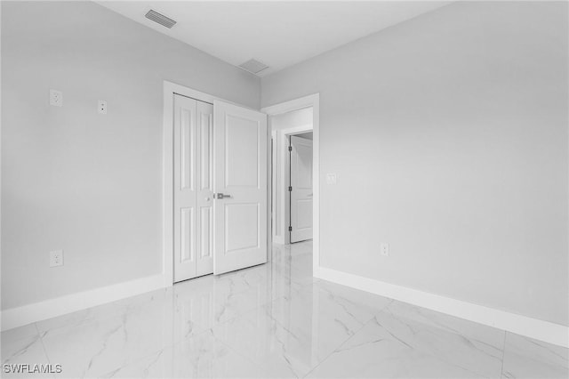 5215 7th St W, Lehigh Acres, FL 33971 - unfurnished bedroom featuring marble look tile flooring, baseboards, and a closet