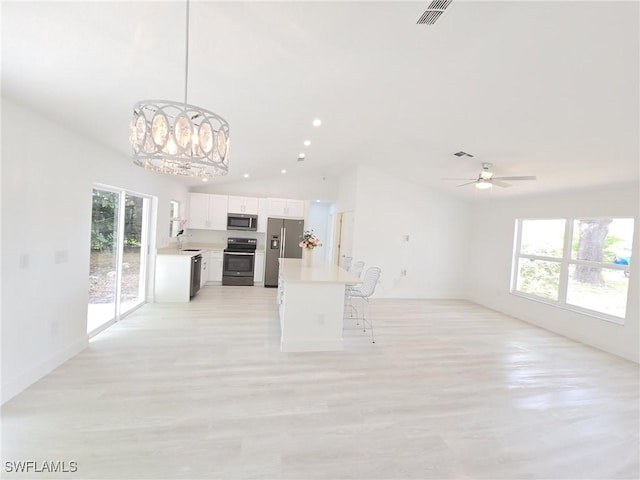 687 Grove Dr, Naples, FL 34120 - kitchen featuring appliances with stainless steel finishes, open floor plan, a chandelier, light countertops, and lofted ceiling