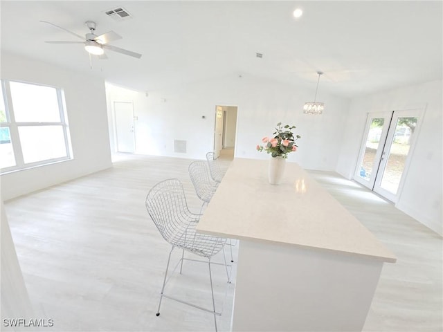 687 Grove Dr, Naples, FL 34120 - kitchen with light wood finished floors, a chandelier, light countertops, ceiling fan, and a kitchen island