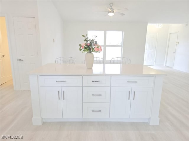 687 Grove Dr, Naples, FL 34120 - kitchen with white cabinetry, light wood-style floors, a ceiling fan, and light countertops