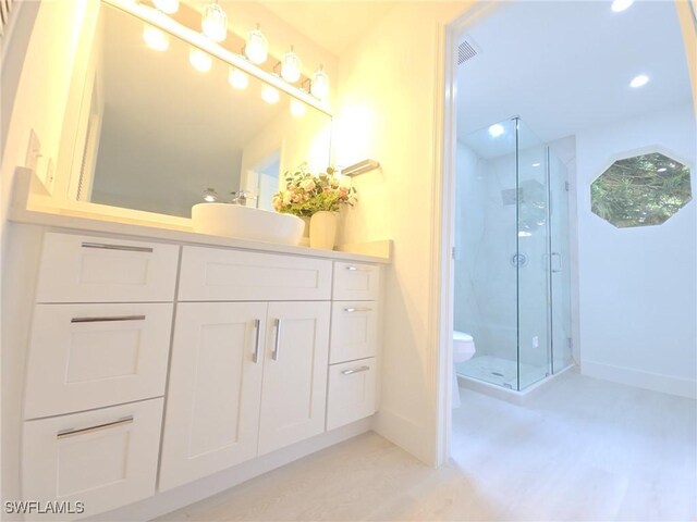 687 Grove Dr, Naples, FL 34120 - full bathroom with a marble finish shower, baseboards, vanity, toilet, and wood finished floors