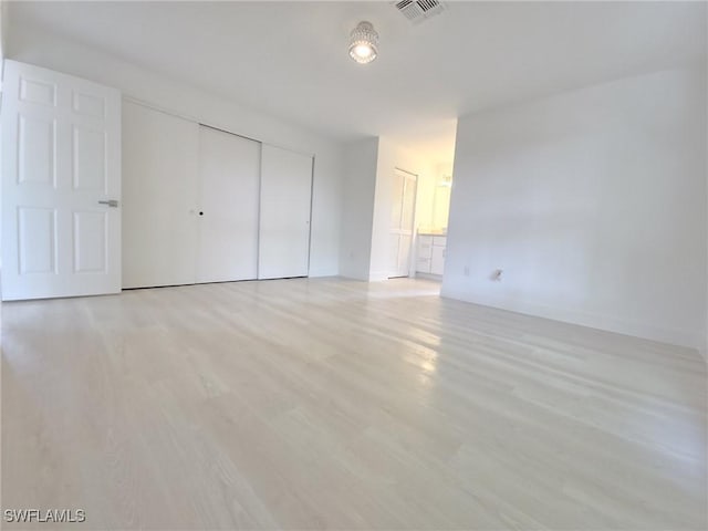 687 Grove Dr, Naples, FL 34120 - unfurnished bedroom featuring a closet, light wood-style flooring, and baseboards