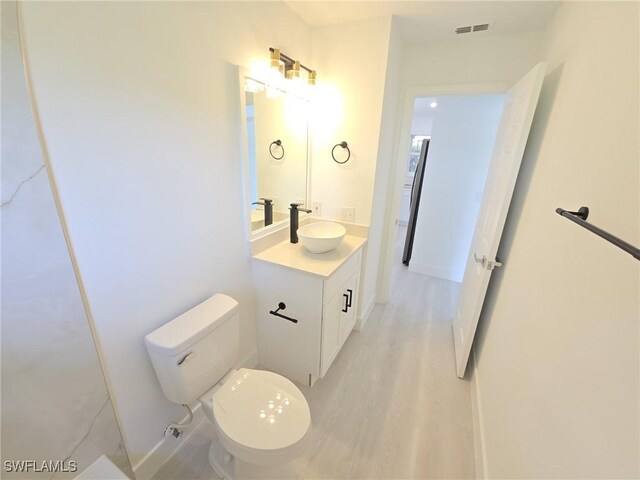 687 Grove Dr, Naples, FL 34120 - bathroom with vanity, toilet, and wood finished floors