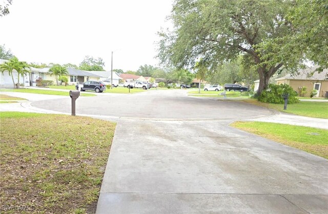 687 Grove Dr, Naples, FL 34120 - view of concrete driveway featuring a residential view