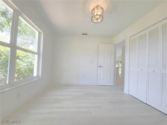687 Grove Dr, Naples, FL 34120 - unfurnished bedroom featuring light wood-style flooring, baseboards, and a closet