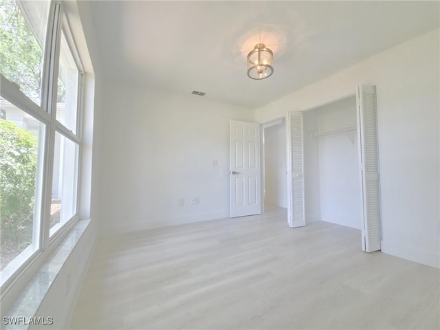 687 Grove Dr, Naples, FL 34120 - unfurnished bedroom with light wood-style flooring, a closet, and baseboards