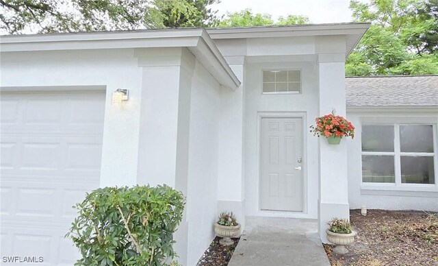 687 Grove Dr, Naples, FL 34120 - entrance to property with a garage and stucco siding