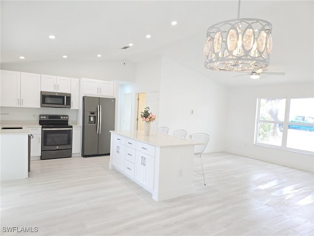687 Grove Dr, Naples, FL 34120 - kitchen featuring appliances with stainless steel finishes, lofted ceiling, a sink, a breakfast bar, and light countertops