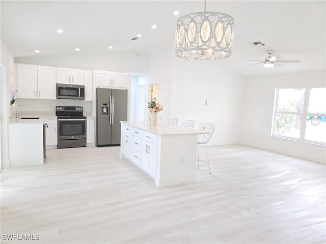 687 Grove Dr, Naples, FL 34120 - kitchen with appliances with stainless steel finishes, lofted ceiling, a breakfast bar, a sink, and light countertops