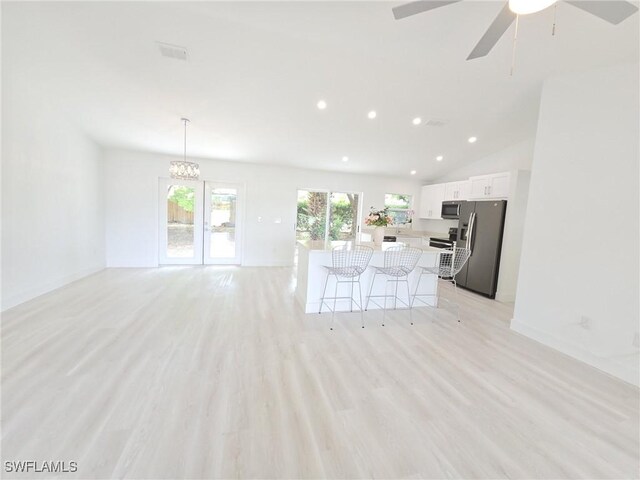 687 Grove Dr, Naples, FL 34120 - unfurnished living room with recessed lighting, light wood-type flooring, a ceiling fan, a chandelier, and lofted ceiling