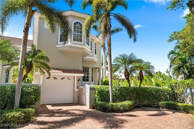 838 9th Ave S Unit 106, Naples, FL 34102 - mediterranean / spanish house featuring stucco siding, a garage, decorative driveway, a tiled roof, and fence