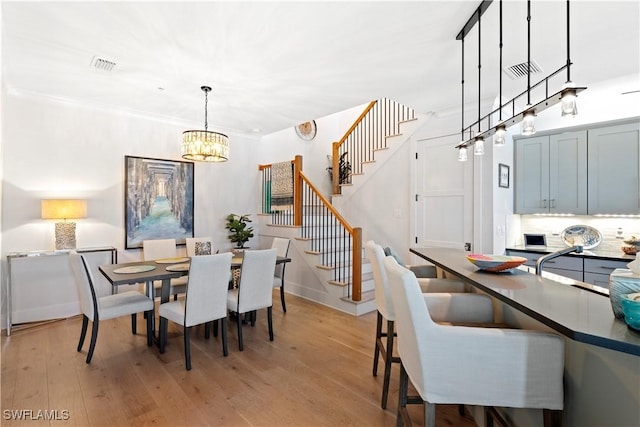 838 9th Ave S Unit 106, Naples, FL 34102 - dining area with a chandelier, stairs, and light wood-style floors