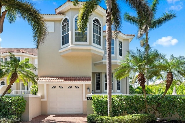 838 9th Ave S Unit 106, Naples, FL 34102 - view of front facade with stucco siding, a tiled roof, a garage, and decorative driveway