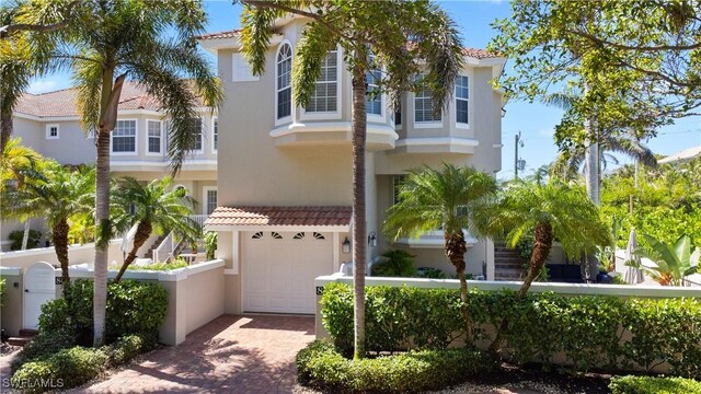 838 9th Ave S Unit 106, Naples, FL 34102 - mediterranean / spanish-style home featuring stucco siding, decorative driveway, an attached garage, and a tiled roof