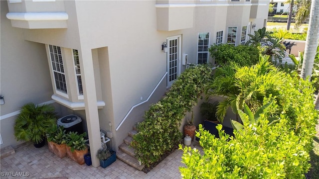 838 9th Ave S Unit 106, Naples, FL 34102 - view of property exterior with stucco siding and cooling unit