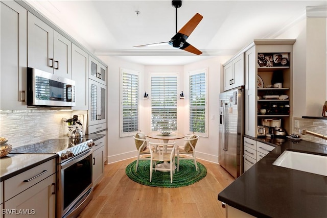 838 9th Ave S Unit 106, Naples, FL 34102 - kitchen with appliances with stainless steel finishes, dark countertops, a sink, decorative backsplash, and light wood-type flooring
