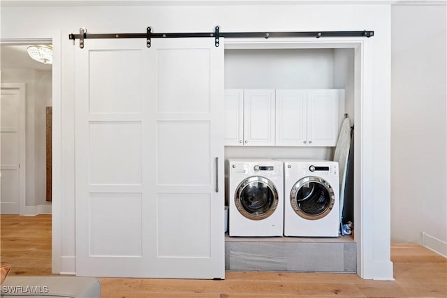 838 9th Ave S Unit 106, Naples, FL 34102 - laundry area featuring washing machine and dryer, light wood-style flooring, and cabinet space