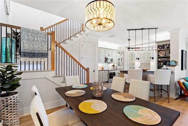 838 9th Ave S Unit 106, Naples, FL 34102 - dining room featuring light wood-style flooring, stairs, ceiling fan, a chandelier, and baseboards
